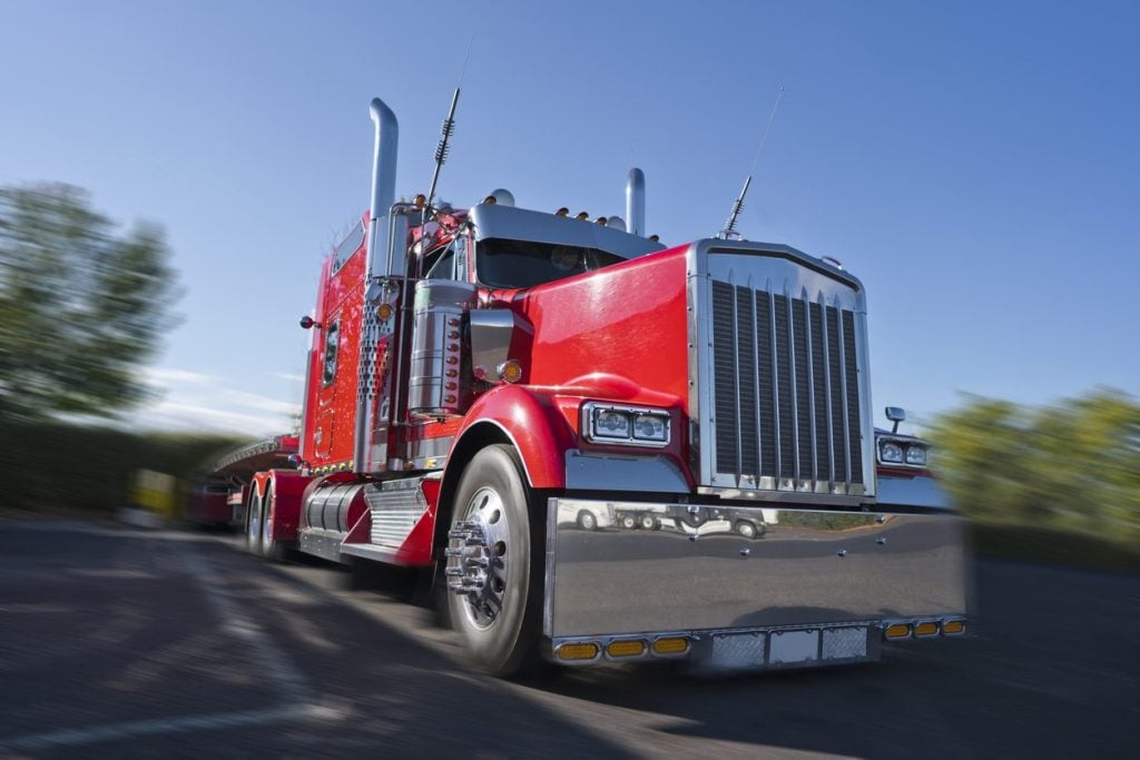 Chromed classic conventional tractor with a flatbed trailer