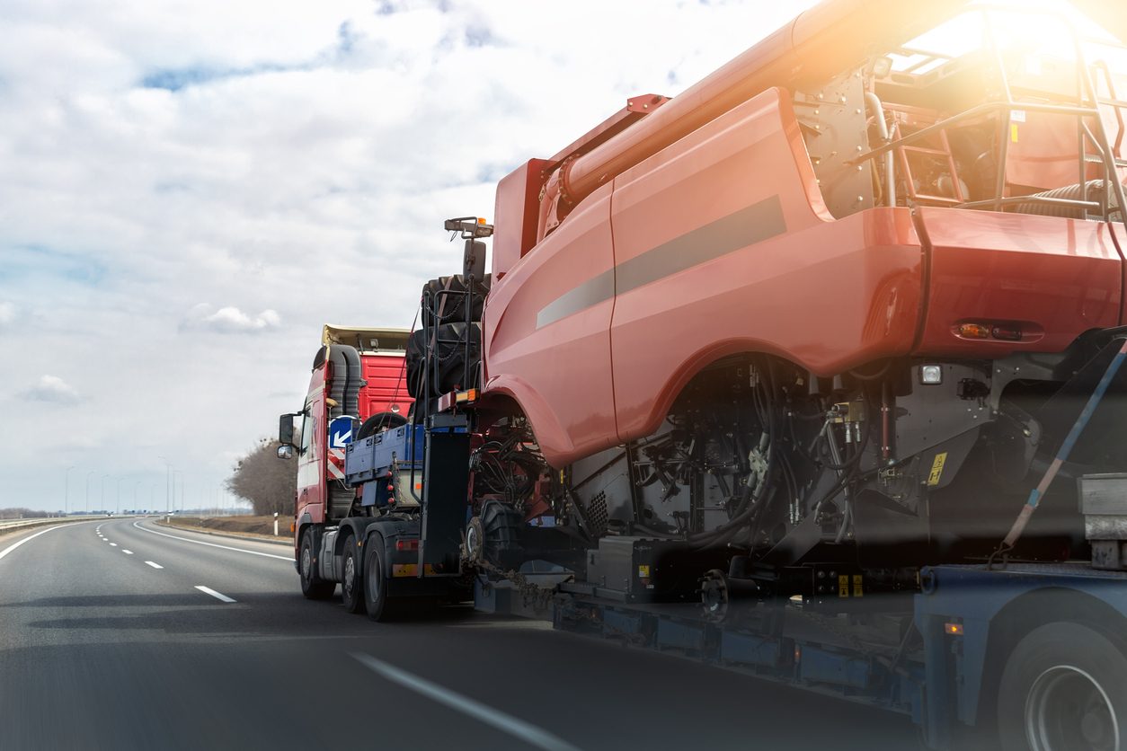 Combine harvester loaded on a step deck trailer on a highway