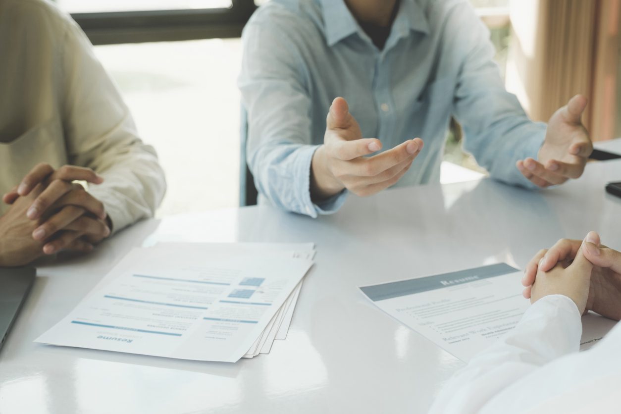 Two people comparing written quotes across a table