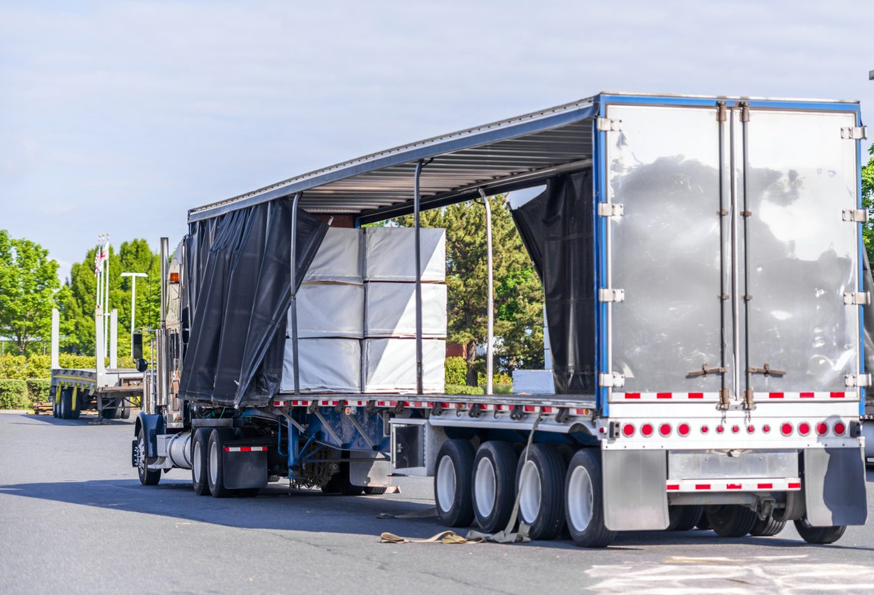 Covered wide load on a curtainside flatbed trailer