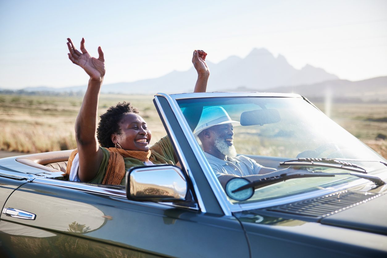 Couple driving a convertible on a road trip