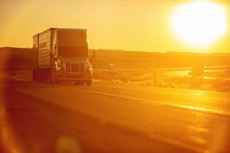 Long haul truck on a western interstate in low golden sunlight