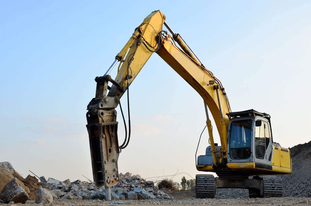 Crawler excavator fitted with a hydraulic breaker on a work site