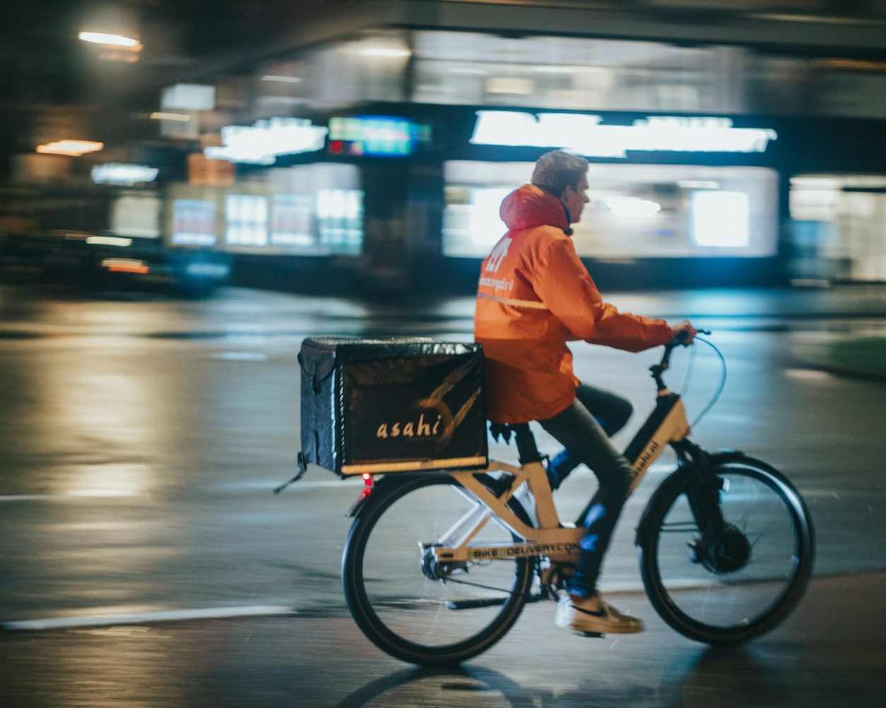 Delivery rider on an electric bike moving through the city at night