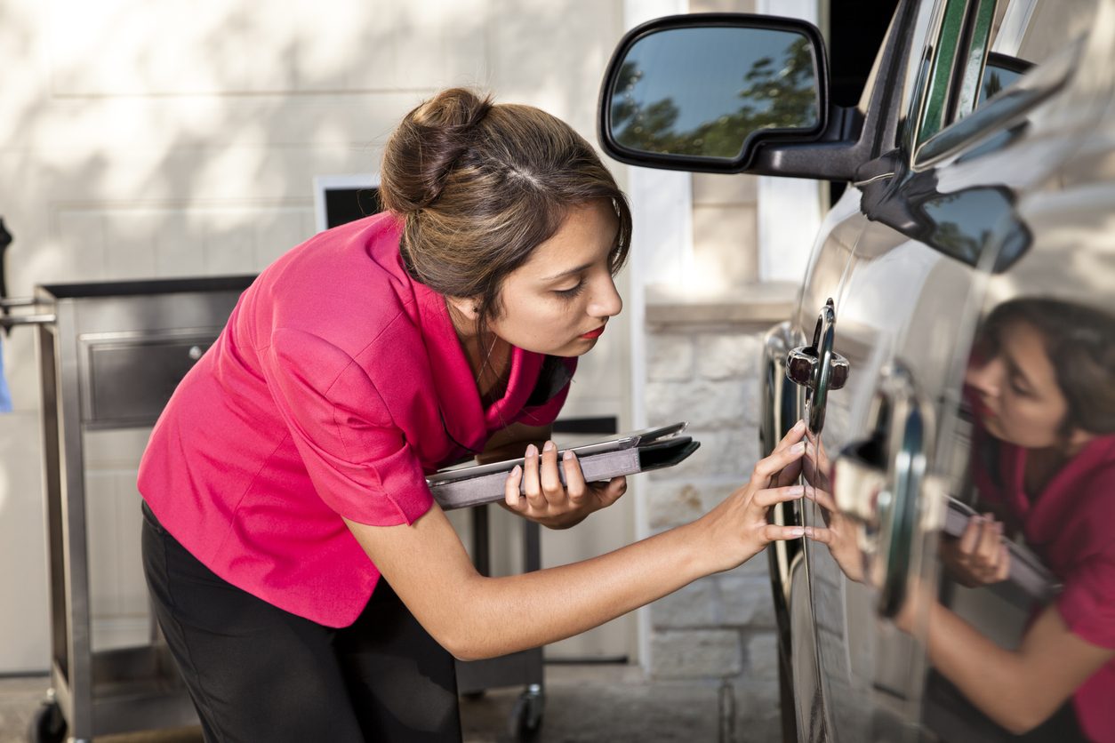 Person photographing a car with a phone to document its condition