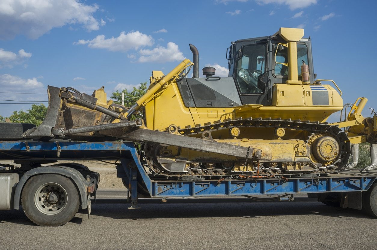 Dozer with ripper shanks loaded on a lowboy trailer