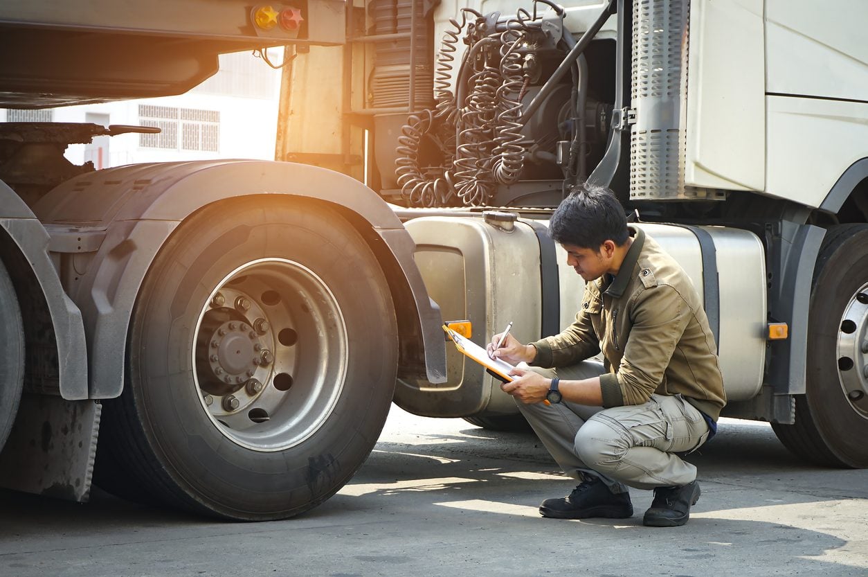 Driver completing a checklist beside the truck