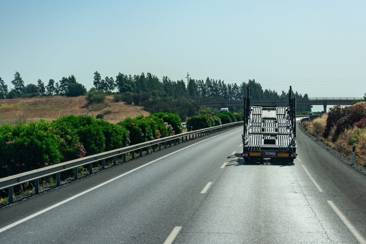 Empty car carrier trailer seen from behind on a highway
