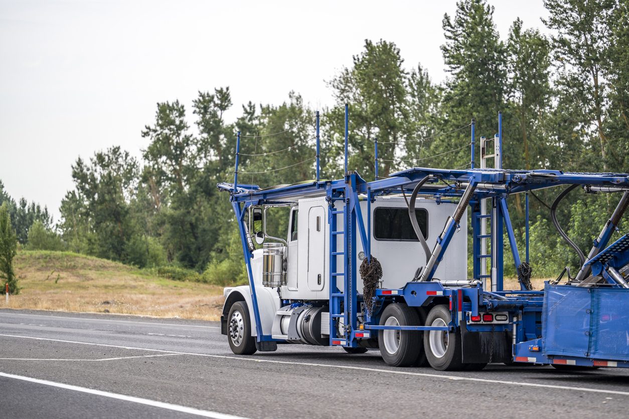 Car hauler with an empty trailer entering a highway