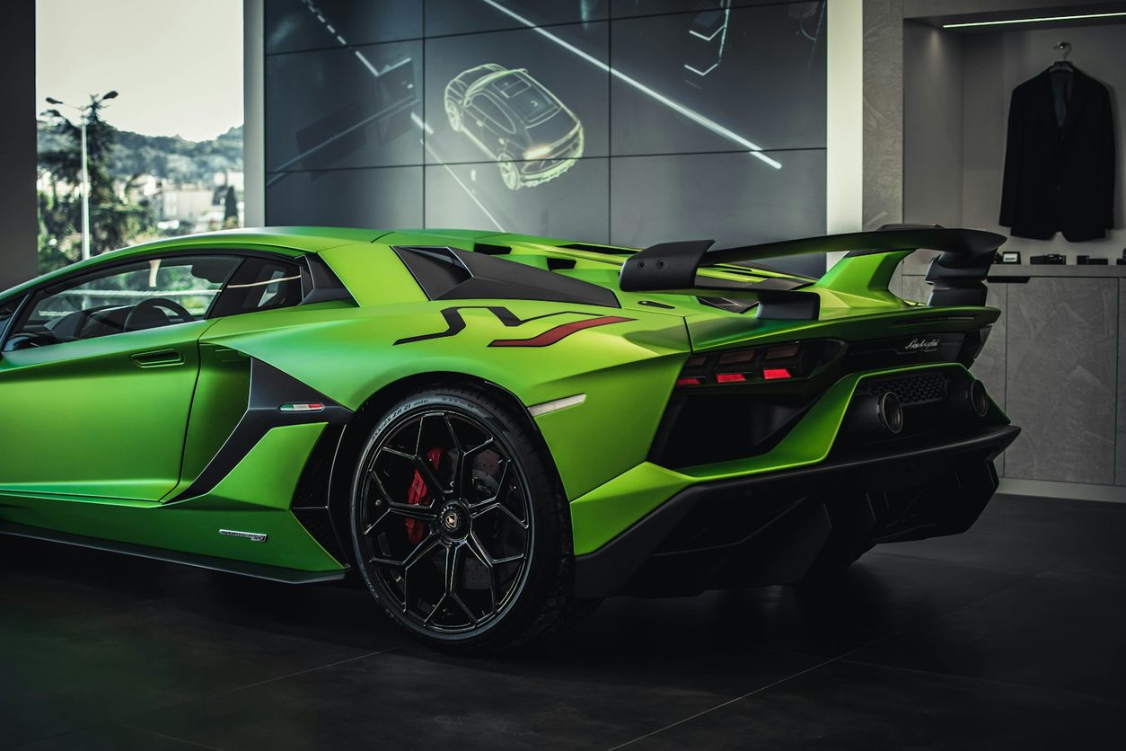 Green Lamborghini Aventador SVJ in a showroom