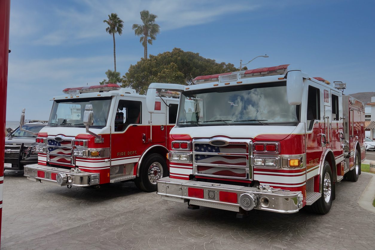 Two fire engines parked front on at a station