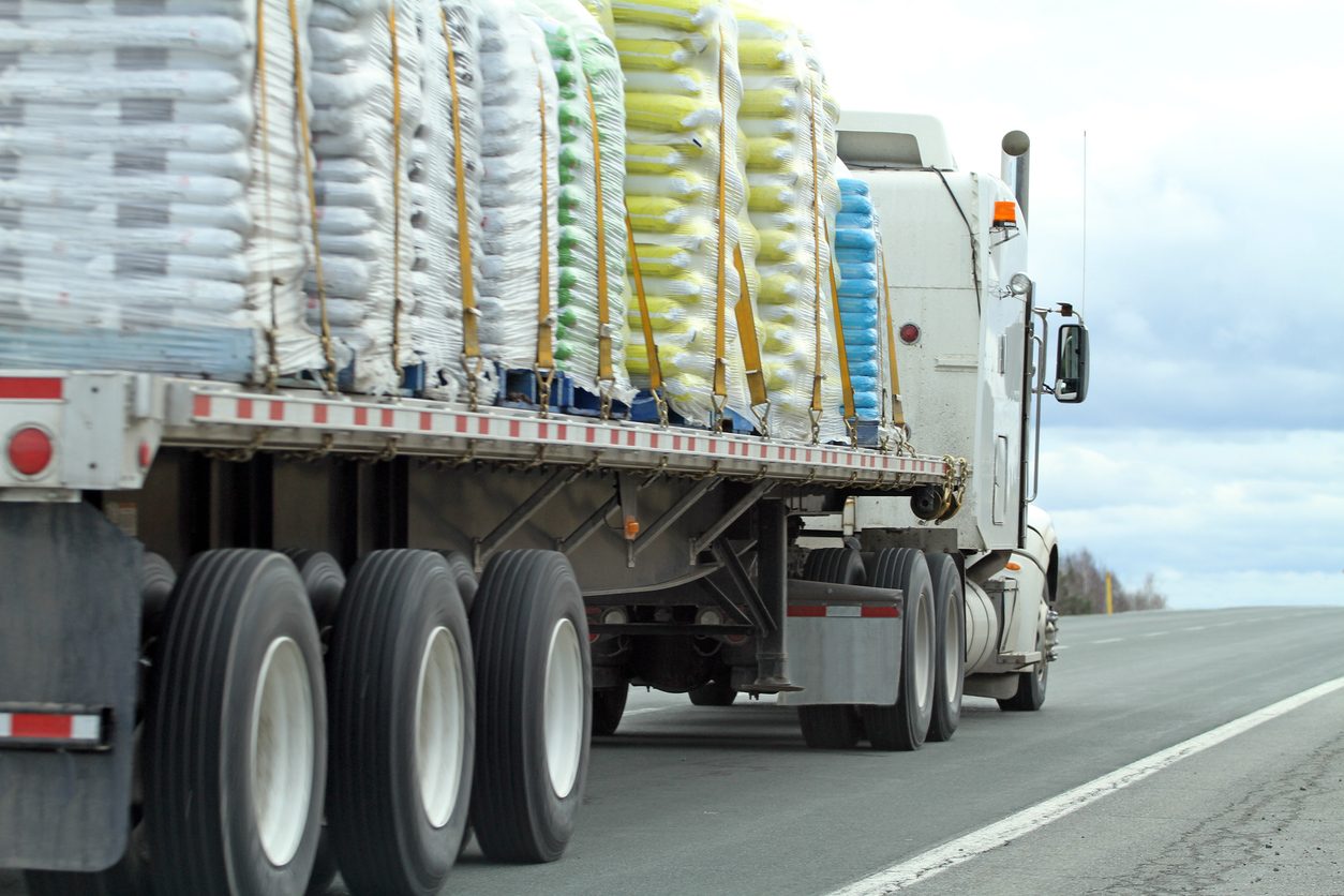 Strapped load secured across a flatbed trailer