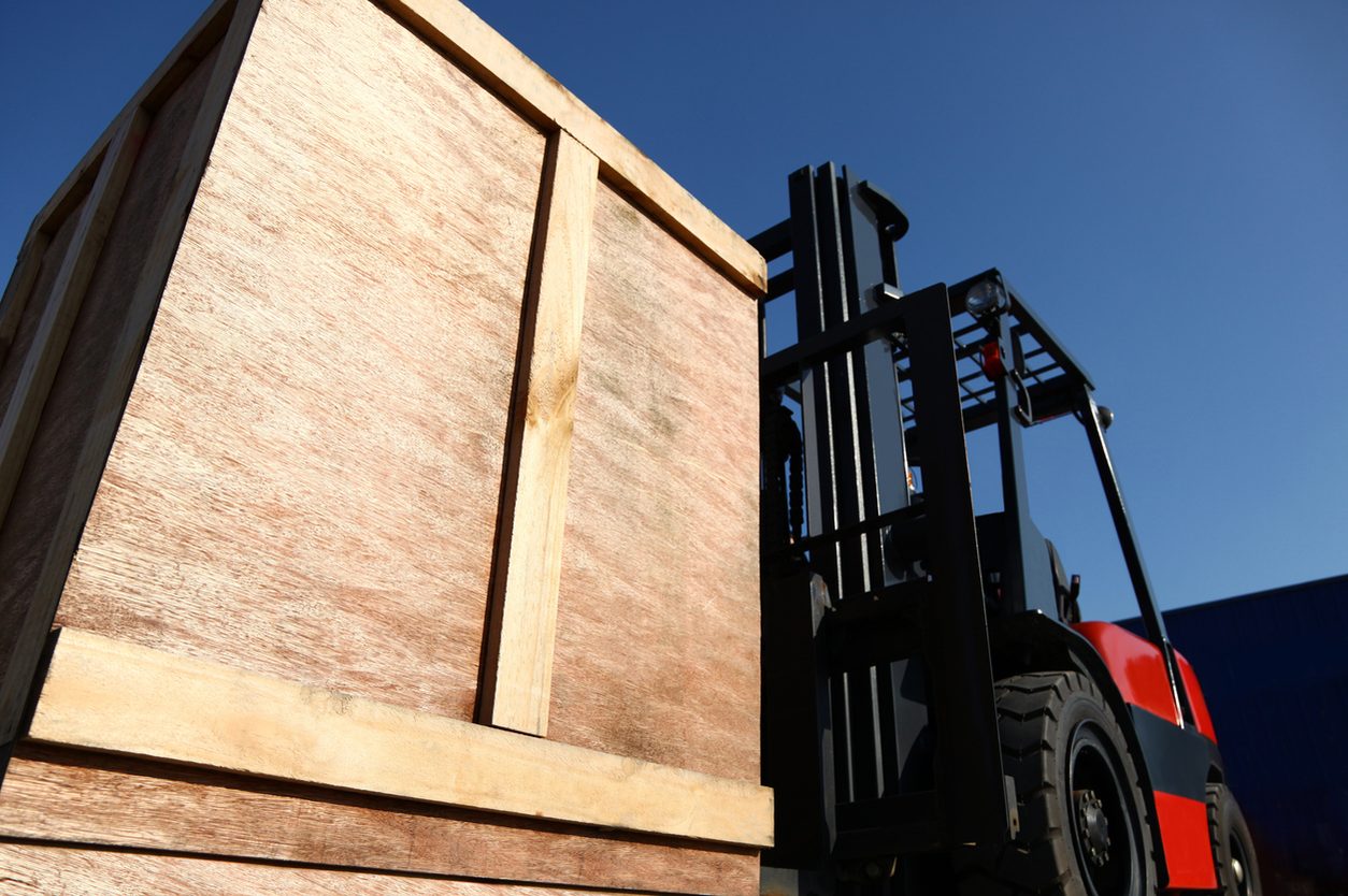 Forklift lifting a large wooden crate