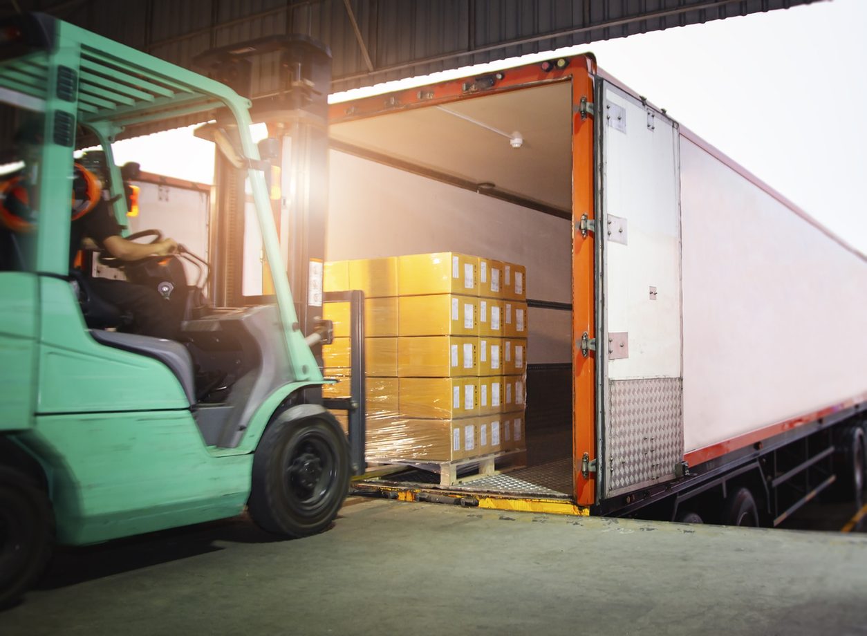 Forklift loading pallets into the back of a box truck