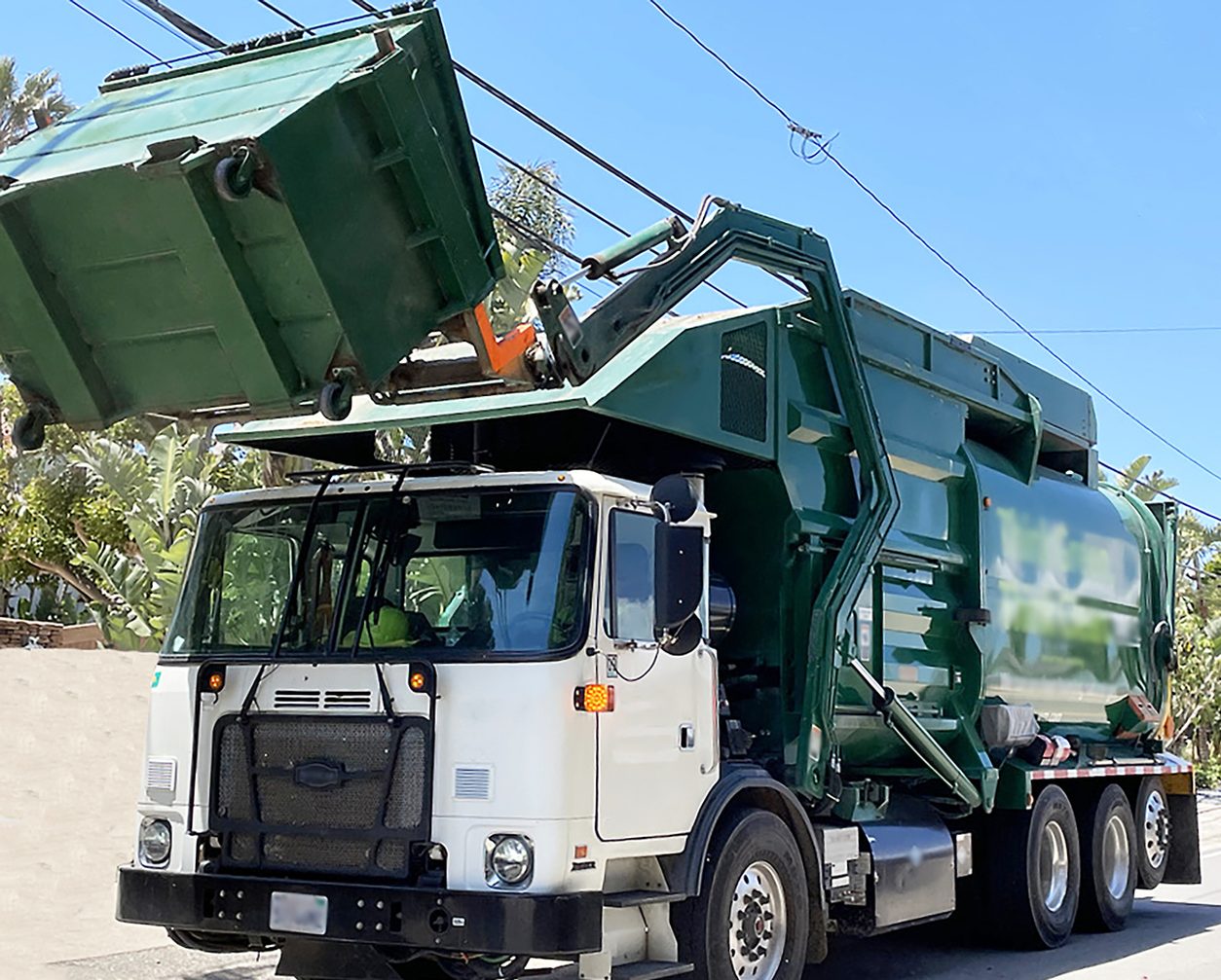 Front loader refuse truck lifting a container