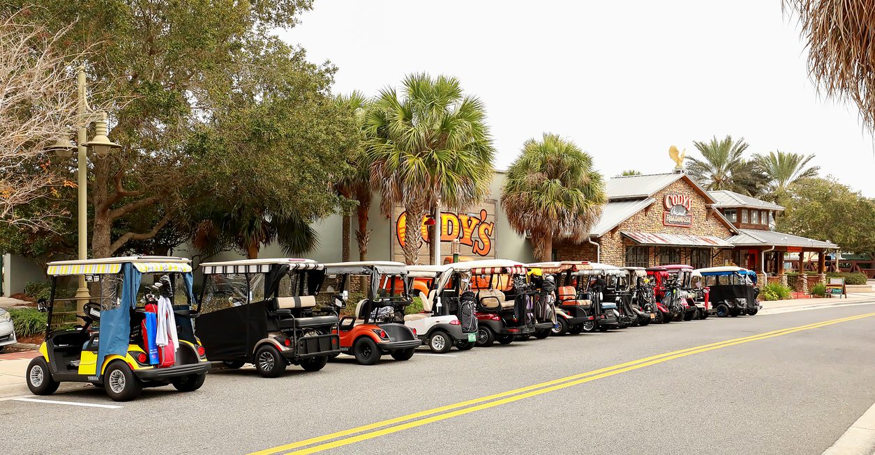 Golf carts parked in a row along a street in The Villages Florida