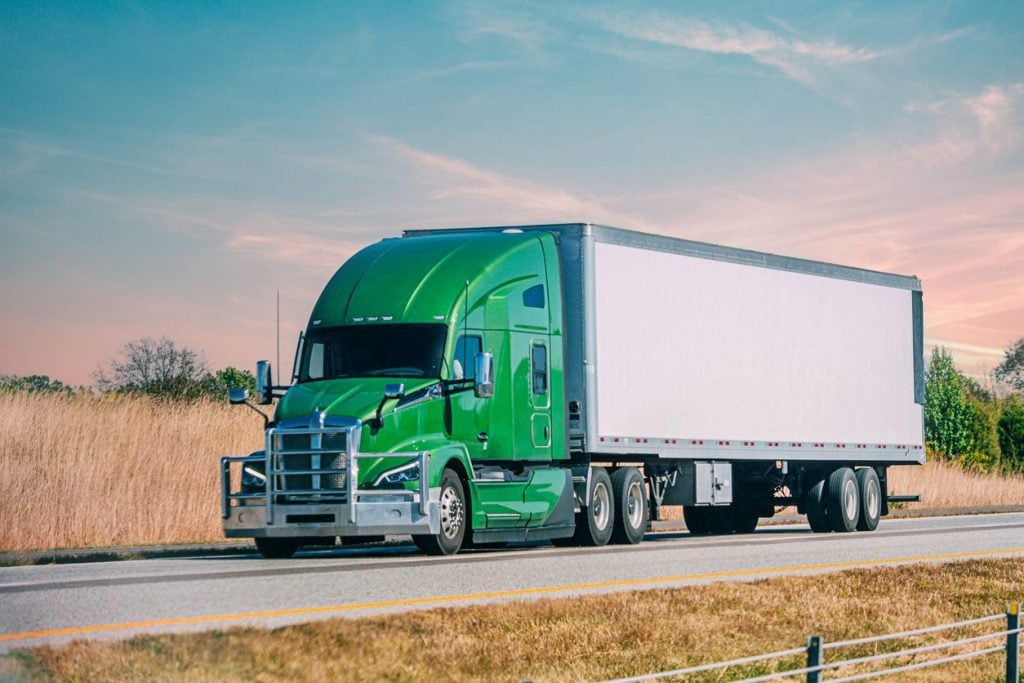 Conventional semi truck running Interstate 70 at sunset