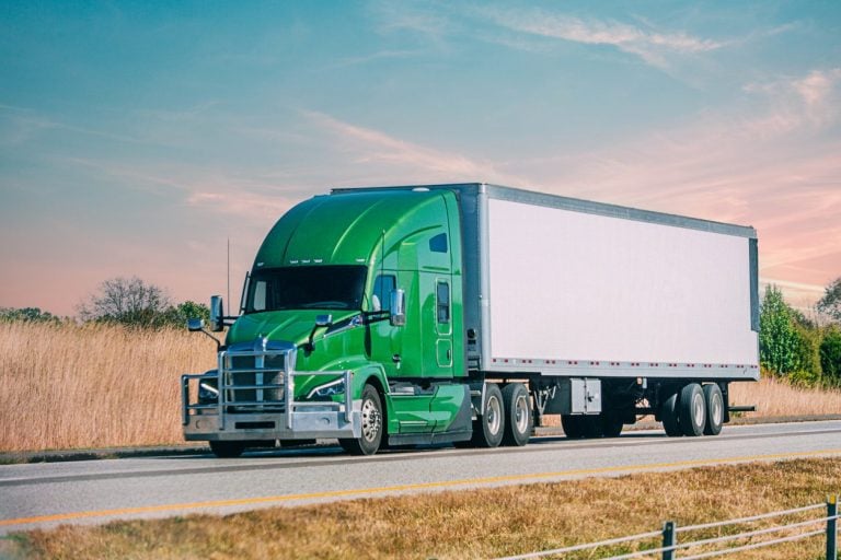 Conventional semi truck running Interstate 70 at sunset