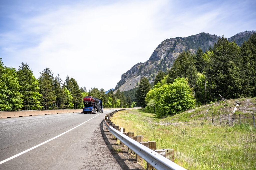 Loaded car hauler on a winding highway