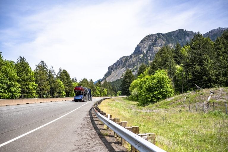 Loaded car hauler on a winding highway