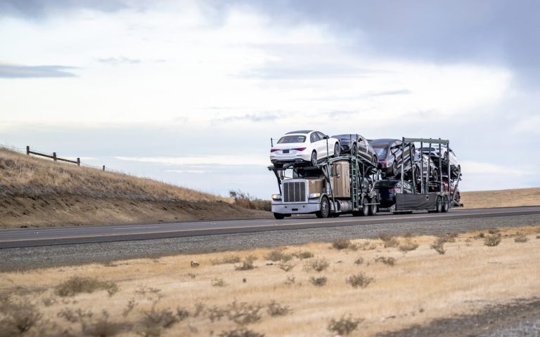 Loaded car hauler traveling an open highway
