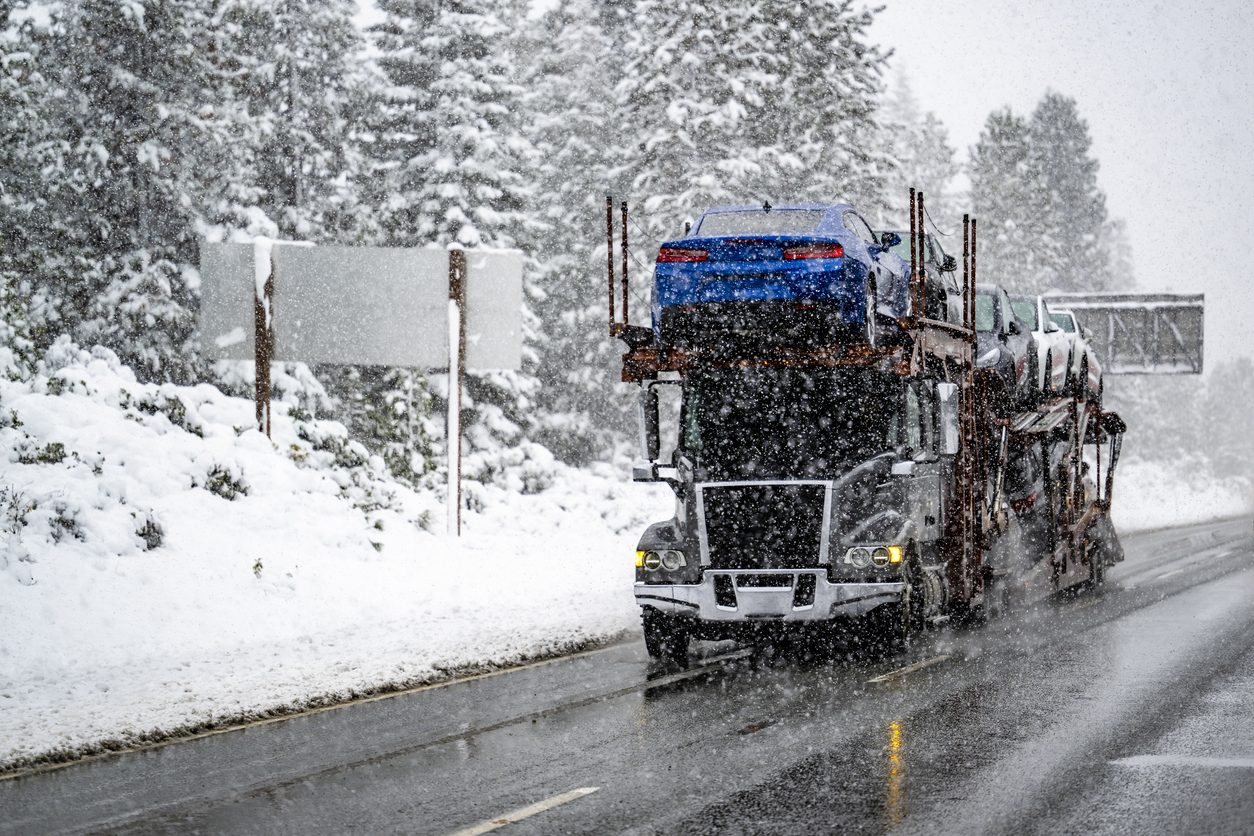 Car hauler running a snow covered highway in winter