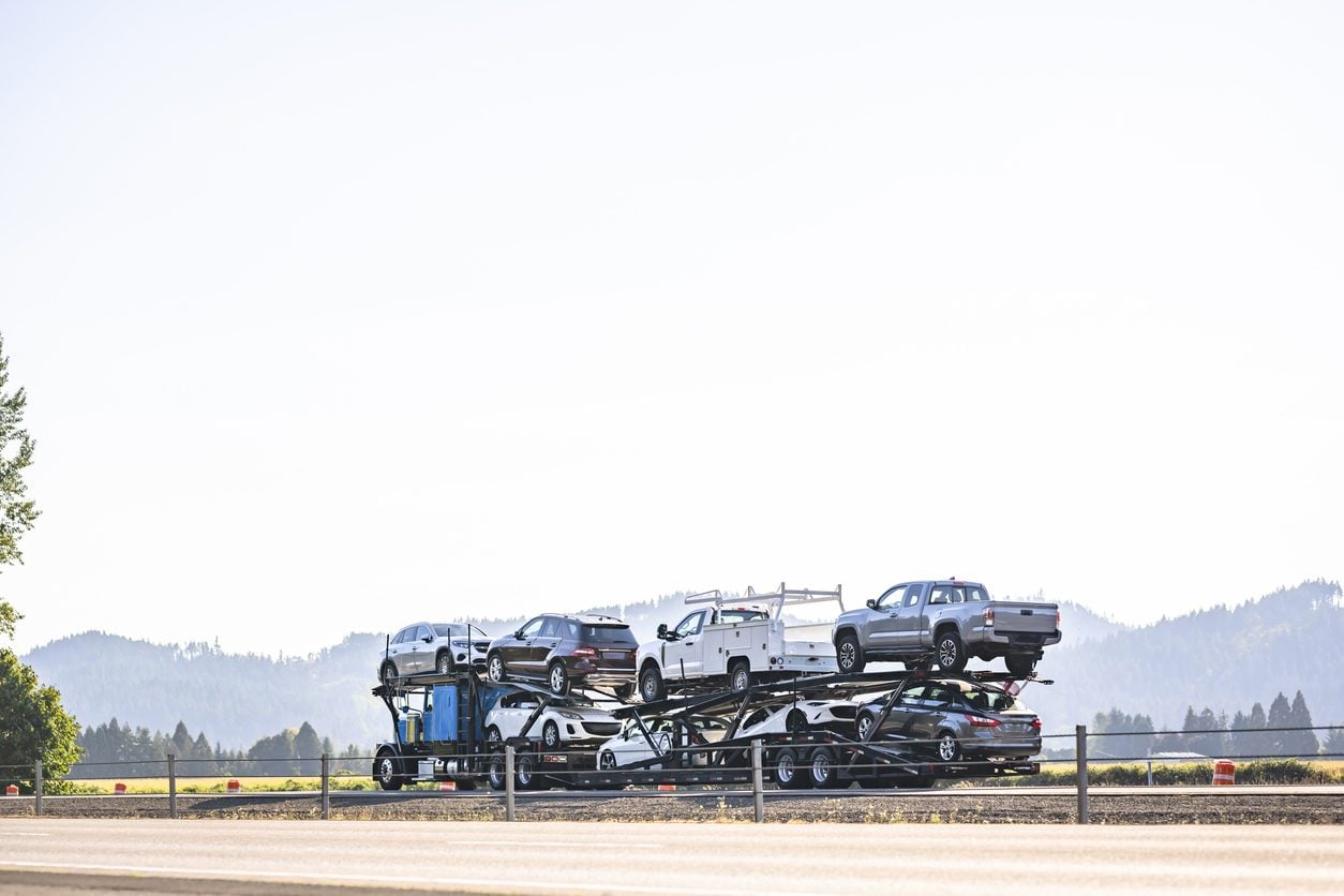 Car hauler carrying crossovers on a mountain highway