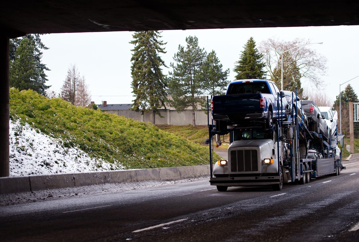 Loaded car hauler traveling a highway in winter conditions