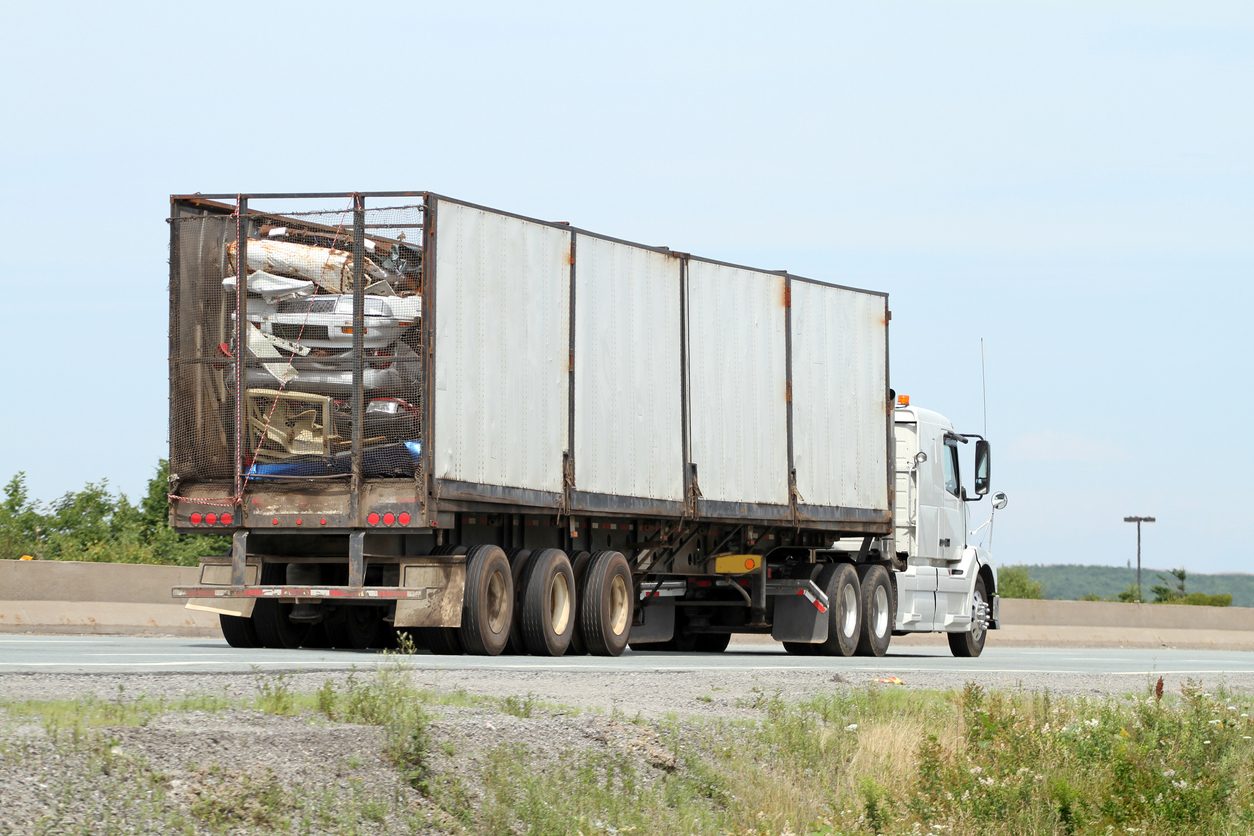 Truck hauling a trailer of scrap metal on a highway