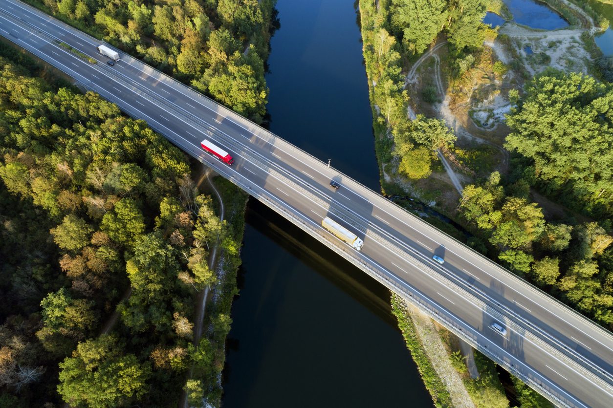 Aerial view of a highway bridge crossing a wooded river