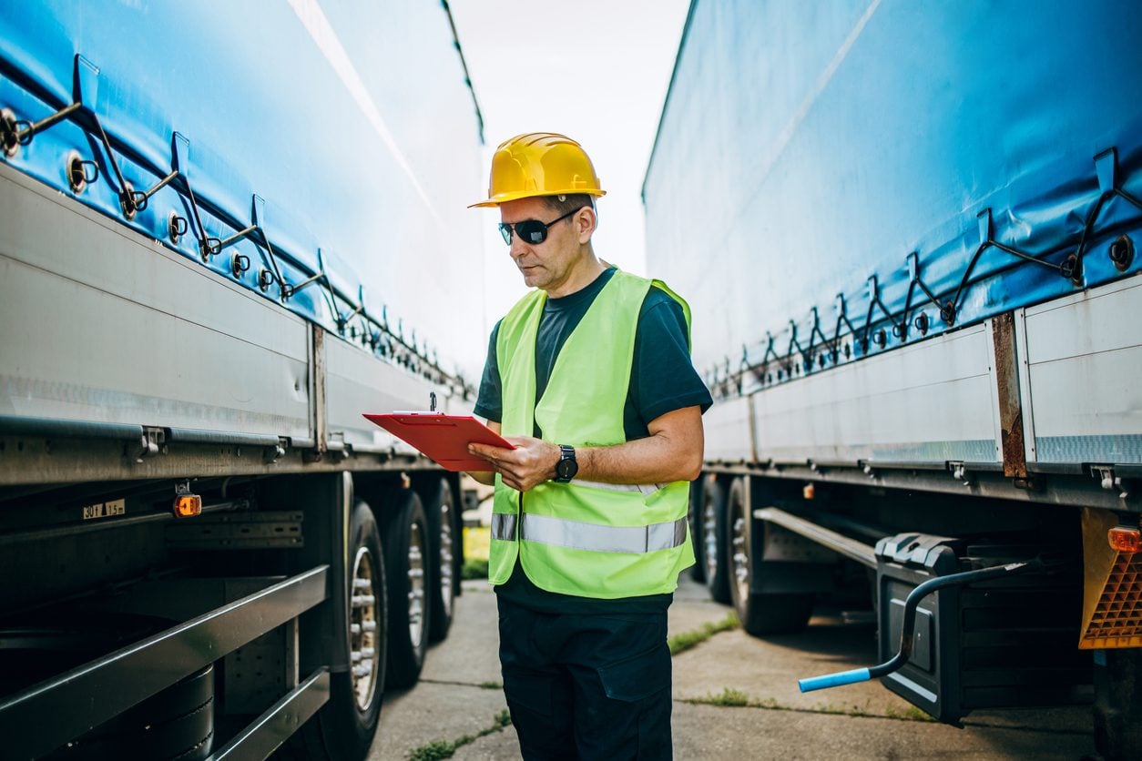 Inspector with a clipboard checking a trailer