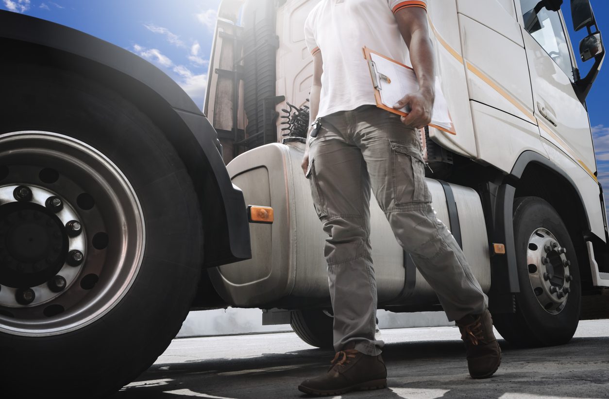 Driver with a clipboard inspecting a tractor unit
