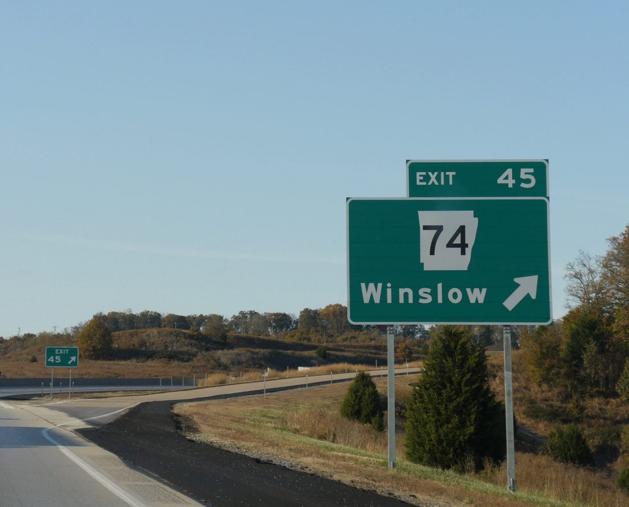 Interstate highway exit sign beside a rural road