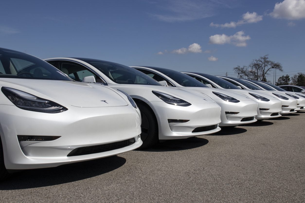 Row of new electric cars awaiting preparation for sale