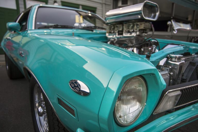 Turquoise American classic car with a supercharged engine at a car show
