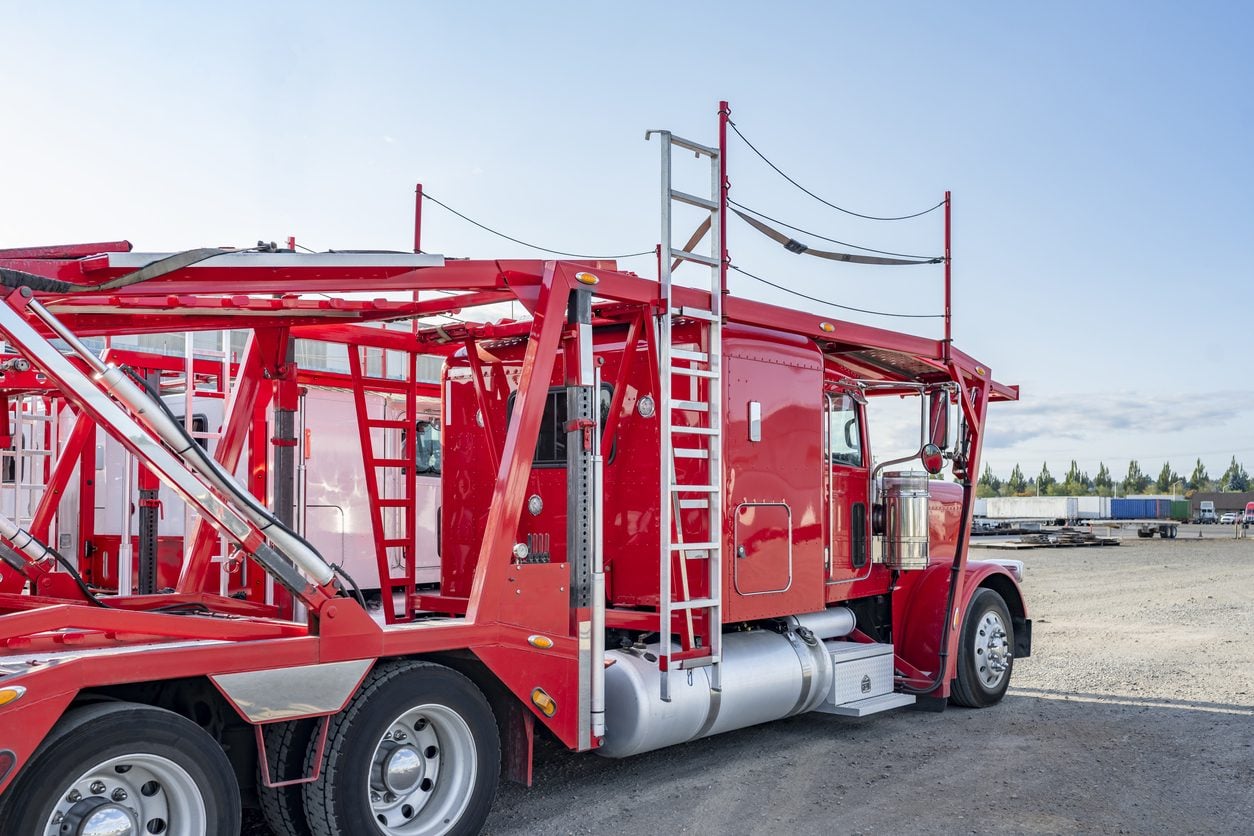 Car hauler rigs parked in a row waiting for their next load