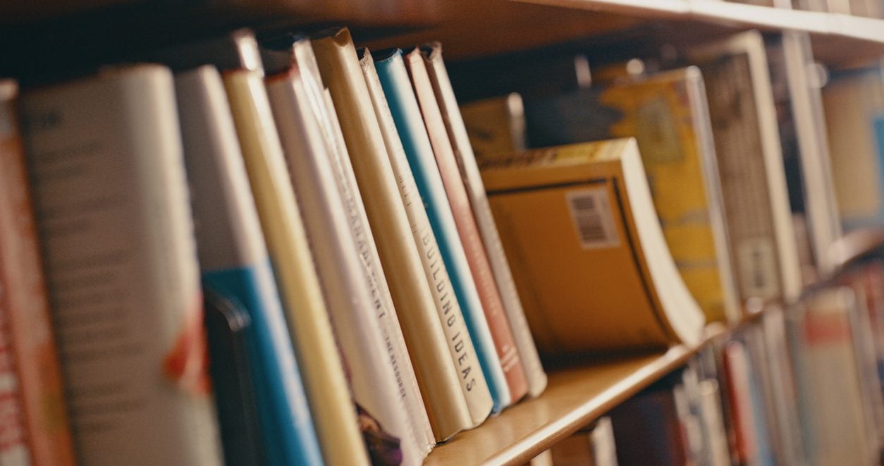 Row of textbooks on a university library shelf