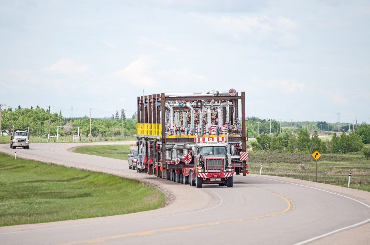 Heavy haul rig carrying an oversize load on a rural highway
