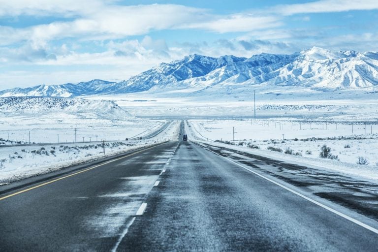 Snow lined expressway running toward mountains in Utah