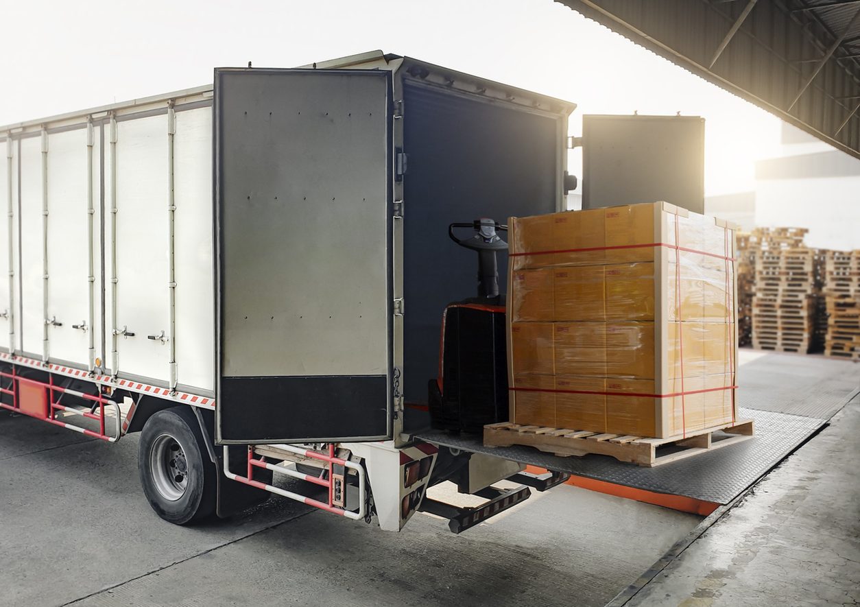 Pallet jack loading a crate onto a truck liftgate