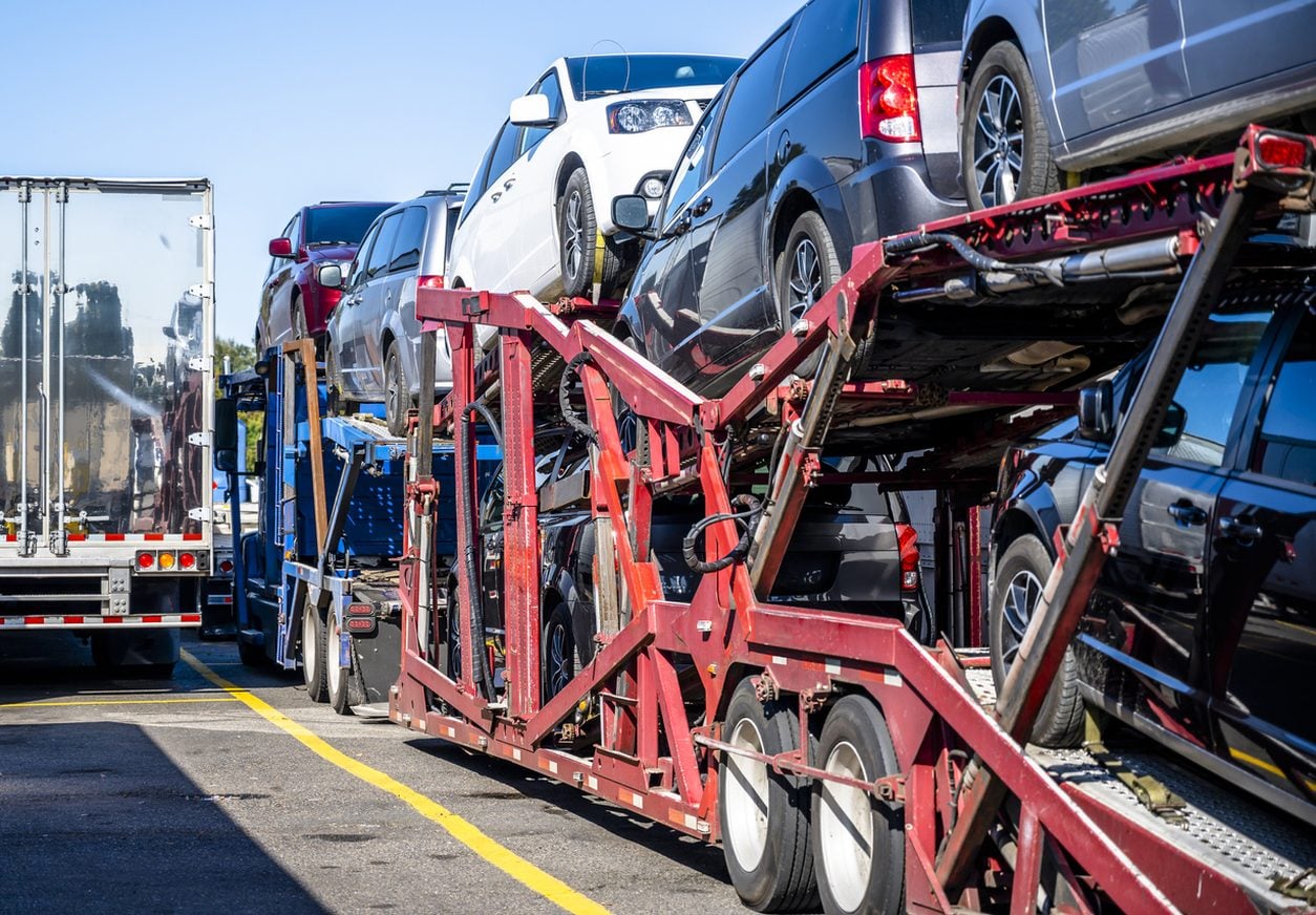 Cars secured on the upper rack of a loaded car hauler
