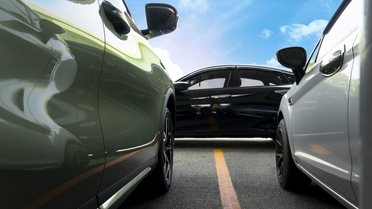 Luxury cars parked close together on a road