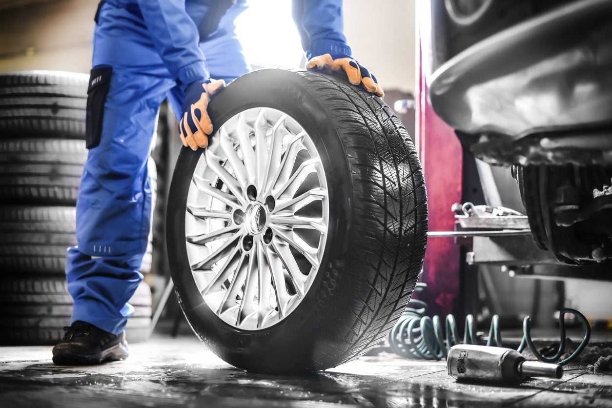 Mechanic working on a wheel in a garage