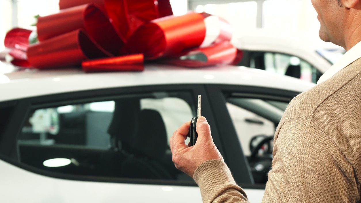 Owner holding the key to a newly purchased car