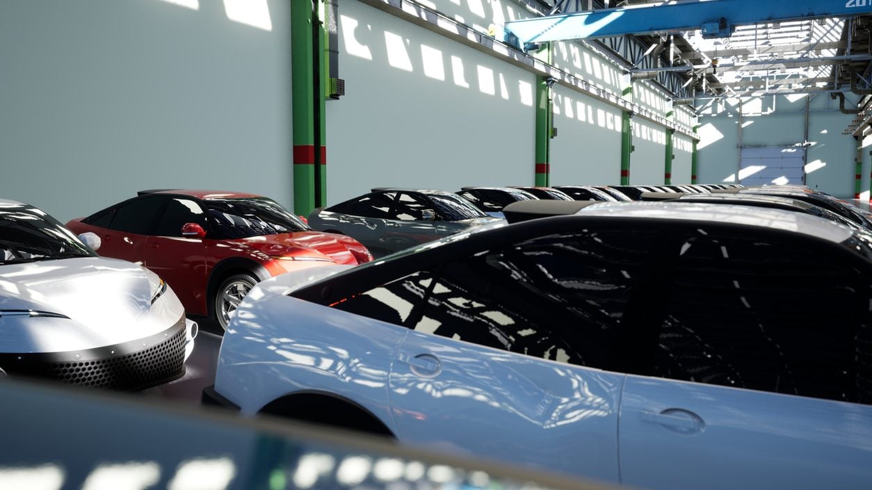 New cars lined up nose to tail inside a plant