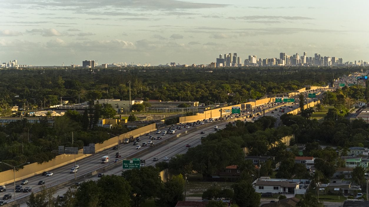 Evening traffic on a North Miami highway with the downtown skyline beyond