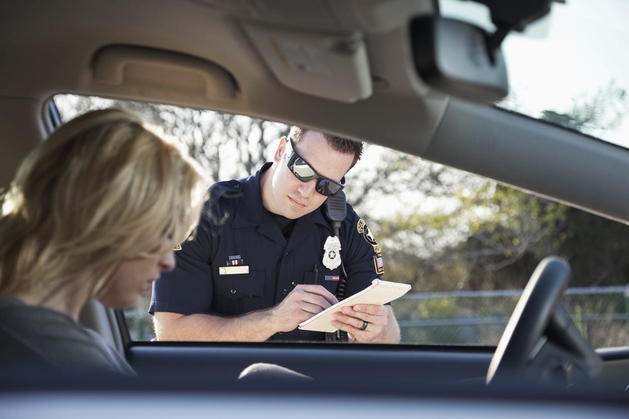 Police officer writing a ticket at a driver window