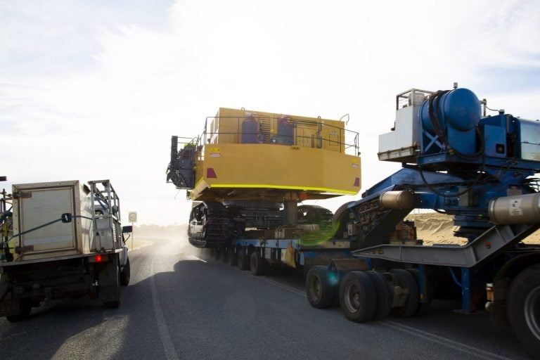Oversize tracked machine on a multi axle lowboy with an escort