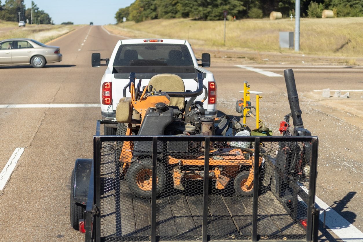 Pickup truck towing a utility trailer on a highway