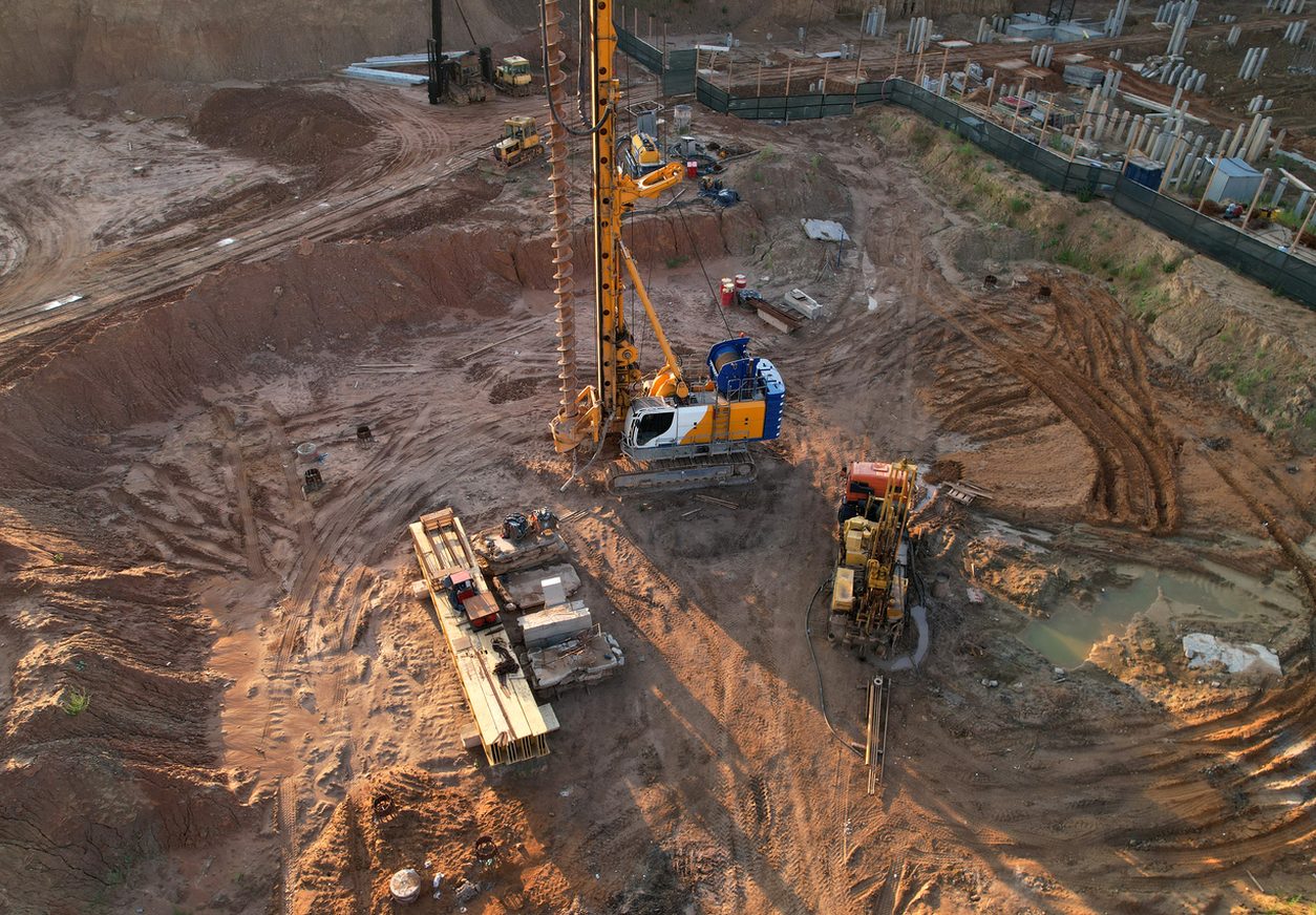 Drilling rig and pile driver at a deep foundation site